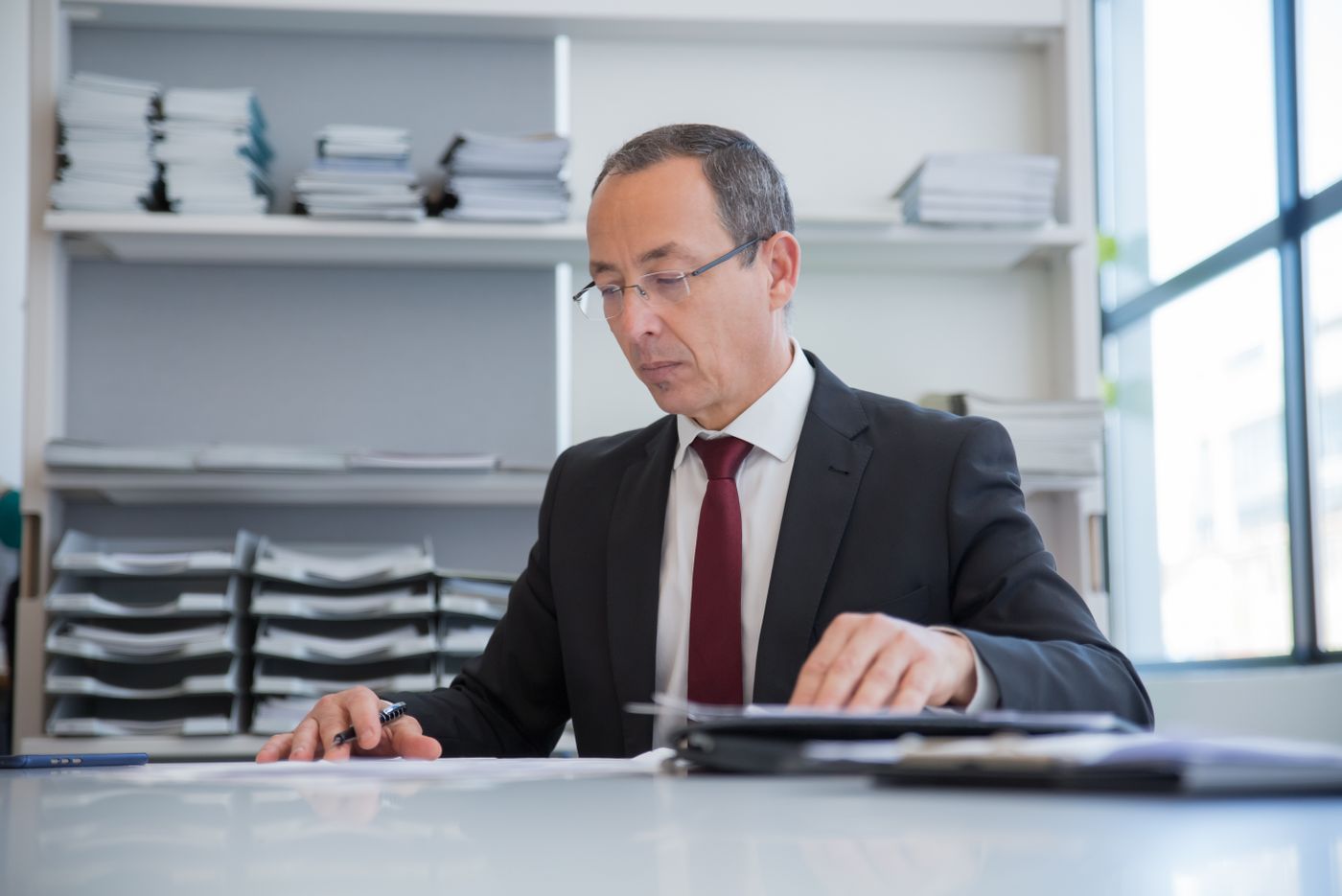 Conseiller en costume examinant des documents dans son bureau